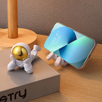 Astronaut figure phone stand holding a smartphone